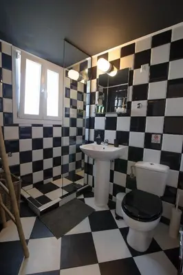 a bathroom with a black and white checkered floor at Smart renovated studio downtown Athens in Athens