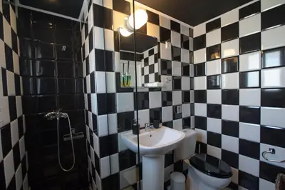 a bathroom with black and white tiled walls and a sink at Smart renovated studio downtown Athens in Athens