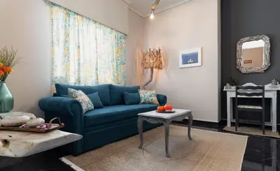 a living room with a blue couch and a table at Athens Flower Apartment in Athens