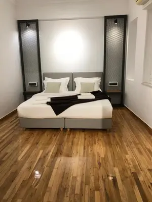 a bedroom with a bed and a wooden floor at Athens Oasis in Athens