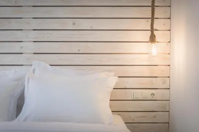 a bed with white pillows and a wooden wall at Athens Oasis in Athens