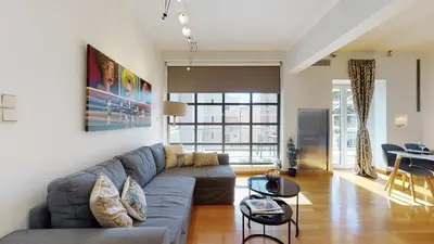a living room with a couch and a table at Penthouse of light @ Koukaki in Athens