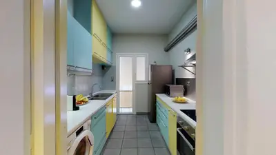 a kitchen with blue cabinets and white counter tops at Penthouse of light @ Koukaki in Athens