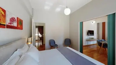 a bedroom with a bed and a living room at Penthouse of light @ Koukaki in Athens