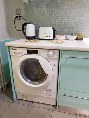 a washing machine under a counter in a kitchen at Penthouse of light @ Koukaki in Athens