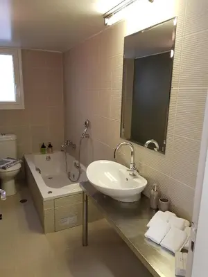 a bathroom with a sink and a tub and a toilet at Penthouse of light @ Koukaki in Athens