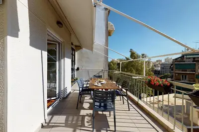 a patio with a table and chairs on a balcony at Penthouse of light @ Koukaki in Athens