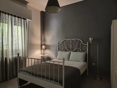a bedroom with a bed with a black wall at Top GroundFloor in Mets in Athens