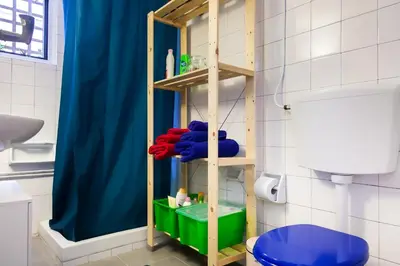 a bathroom with a blue shower curtain and a blue toilet at Top GroundFloor in Mets in Athens