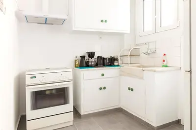 a white kitchen with a stove and a sink at Top GroundFloor in Mets in Athens