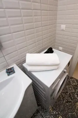 a bathroom with a white sink and towels on a counter at White Lux Apartment For 2 VIPGreece in Athens