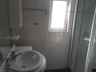 a bathroom with a toilet and a sink and a window at Sea view,big and comfortable appartment in Voula in Athens