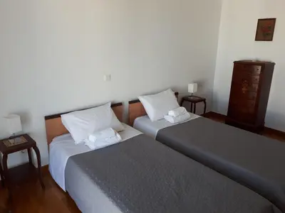 a bedroom with two beds and a dresser at Sea view,big and comfortable appartment in Voula in Athens