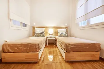 two beds in a room with two windows at Chloe Boutique Apartments Metropolis in Athens