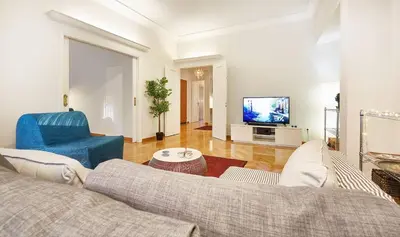 a living room with a couch and a tv at Chloe Boutique Apartments Metropolis in Athens