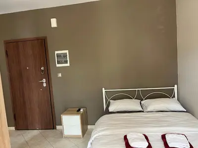 a bedroom with a bed and a wooden door at Paidon Studio in Athens