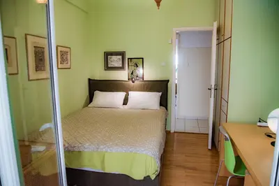 a small bedroom with a bed and a desk at Sophie's Penthouse in Athens in Athens