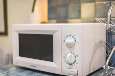 a white microwave oven sitting on top of a counter at Amazing Apartment Pallini - Near Airport & Metro in Pallíni