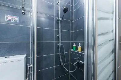 a bathroom with a shower with a glass door at Amazing Apartment Pallini - Near Airport & Metro in Pallíni
