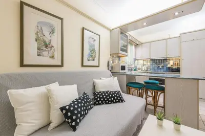 a living room with a couch and a kitchen at Amazing Apartment Pallini - Near Airport & Metro in Pallíni