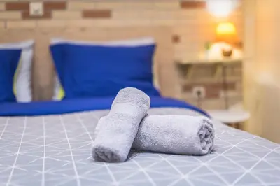 a towel laying on top of a bed at Amazing Apartment Pallini - Near Airport & Metro in Pallíni