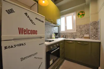 a kitchen with a welcome sign on the wall at Cosy appartment in the heart of Athens in Athens