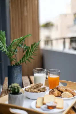 a table with two plates of food and two glasses of milk at The Omnia Collection Pagrati in Athens