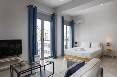 a living room with a bed and a tv at The Omnia Collection Pagrati in Athens