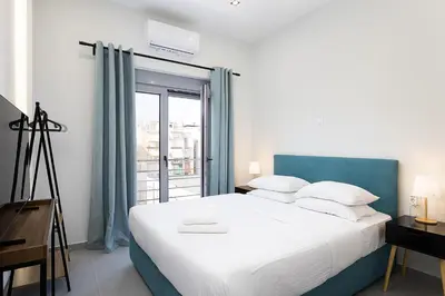 a bedroom with a large white bed and a window at The Omnia Collection Pagrati in Athens