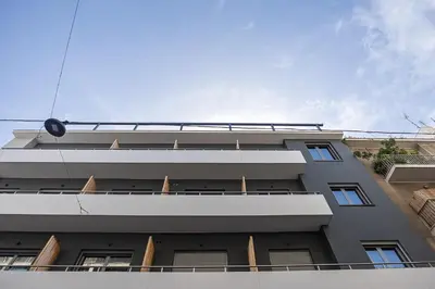 a gray building with a sky in the background at The Omnia Collection Pagrati in Athens