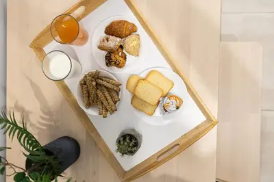 a table with a plate of food and a glass of orange juice at The Omnia Collection Pagrati in Athens
