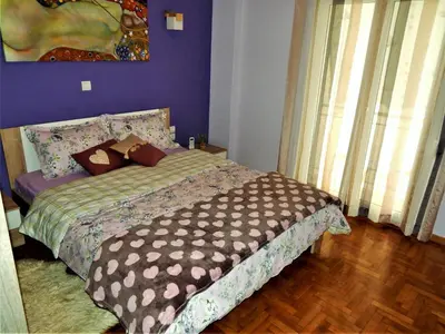 a bedroom with a bed with a purple wall at ANNA in Athens