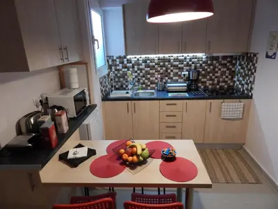 a kitchen with a table with a bowl of fruit on it at ANNA in Athens