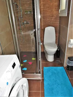 a bathroom with a shower with a toilet and a blue rug at ANNA in Athens
