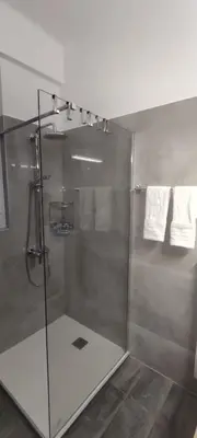 a bathroom with a shower with a glass door at Parthenon View Apt in Athens