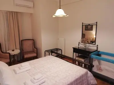 a bedroom with a bed and a mirror and a chair at Parthenon View Apt in Athens
