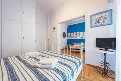 a white bedroom with a bed and a television at Athens Centre Flat 2 min. from Evangelismos Metro in Athens