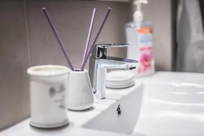 a bathroom sink with two cups and a faucet at Athens Centre Flat 2 min. from Evangelismos Metro in Athens