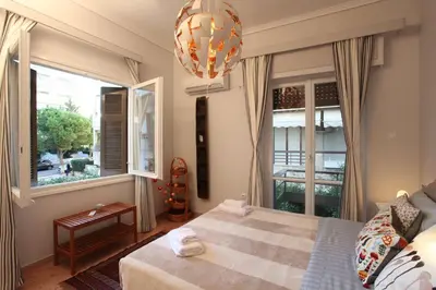 a bedroom with a bed and a large window at Stylish Flat at Edem Beach by Athenian Homes in Athens