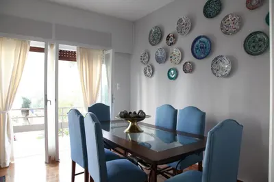 a dining room with a table and blue chairs at Stylish Flat at Edem Beach by Athenian Homes in Athens