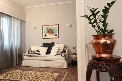 a living room with a couch and a potted plant at Stylish Flat at Edem Beach by Athenian Homes in Athens