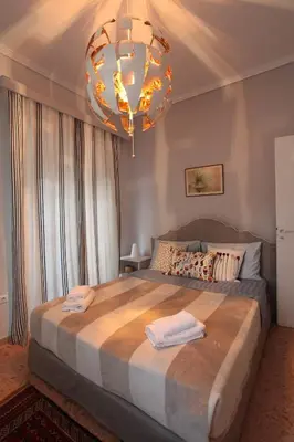 a bedroom with a large bed and a chandelier at Stylish Flat at Edem Beach by Athenian Homes in Athens