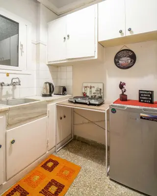 a small kitchen with white cabinets and a sink at Alexandras Metro Studio&200mbps in Athens