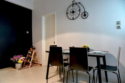 a dining room table with chairs and a clock on the wall at 20 times Athens in Athens