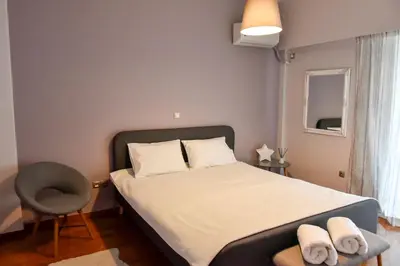 a small bedroom with a bed and a chair at 20 times Athens in Athens