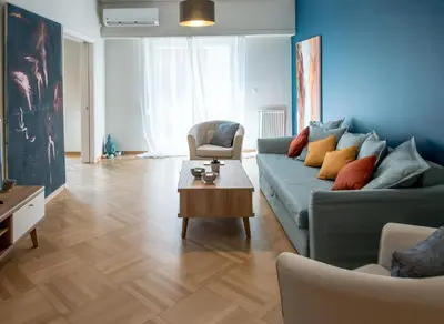 a living room with a blue couch and a table at 24 times Athens in Athens