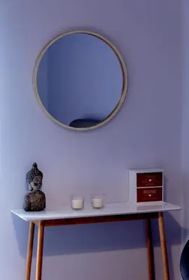 a mirror on a wall above a table with two candles at 24 times Athens in Athens