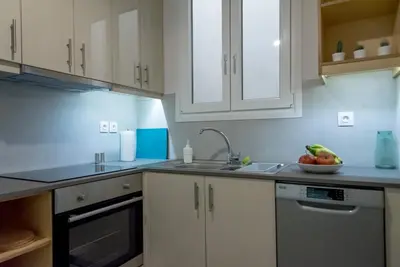 a kitchen with white cabinets and a bowl of fruit on the counter at 24 times Athens in Athens