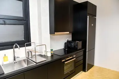 a kitchen with black cabinets and a sink and a microwave at Central apartment at Echarxia 2 beds for 5 pers by MPS in Athens