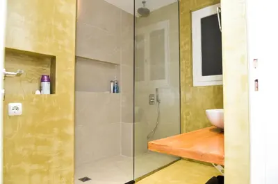 a bathroom with a glass shower with a sink at Central apartment at Echarxia 2 beds for 5 pers by MPS in Athens